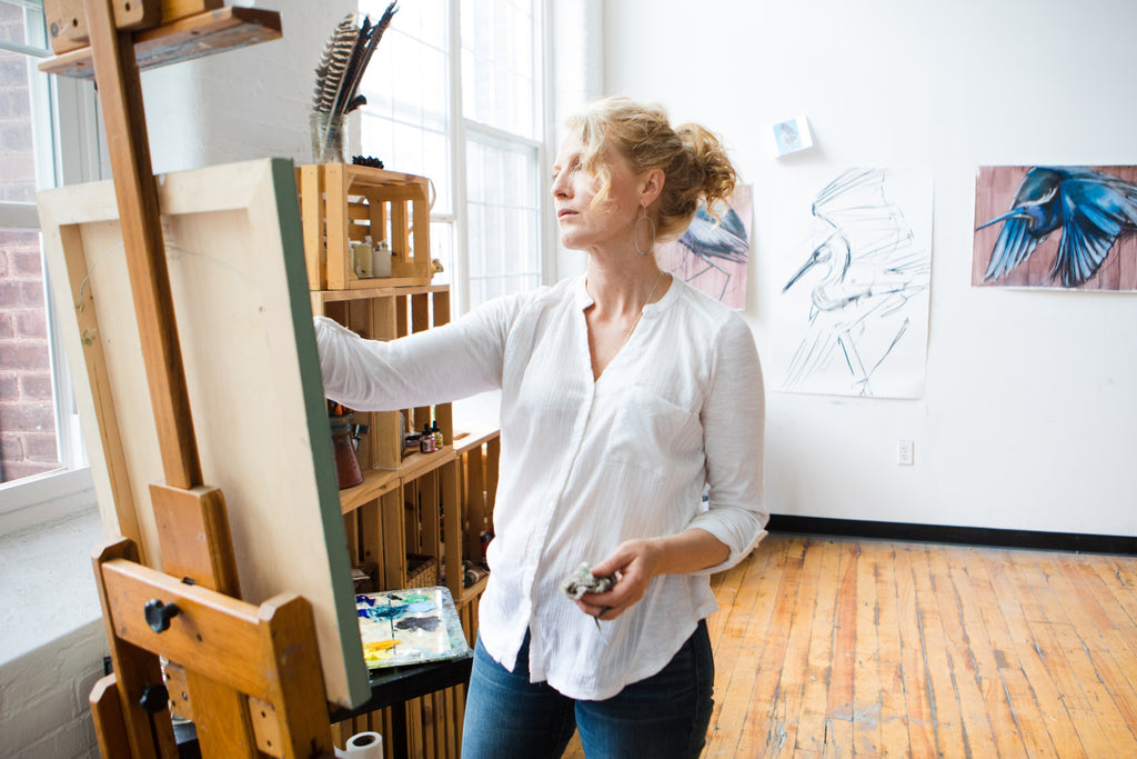 Holly Wach paints original bird artwork at her easel