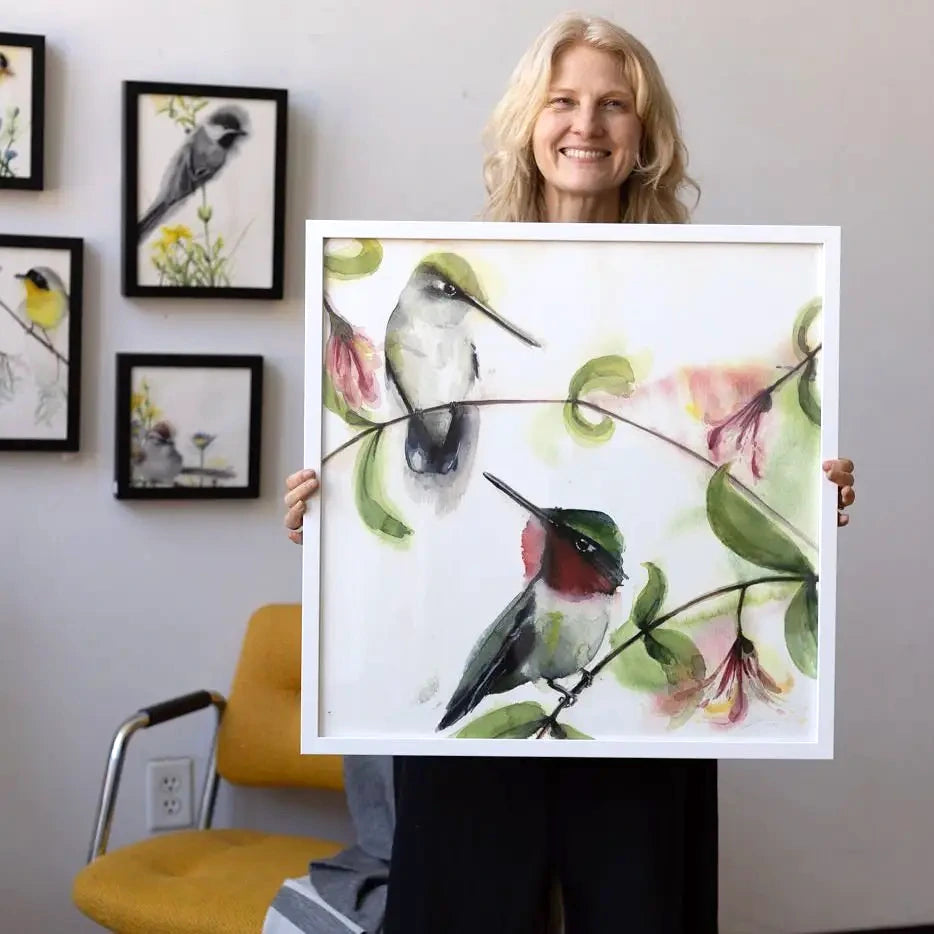 Holly Wach holding large framed original bird watercolor artwork