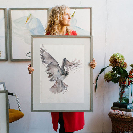 Holly Wach holding large original watercolor raptor artwork