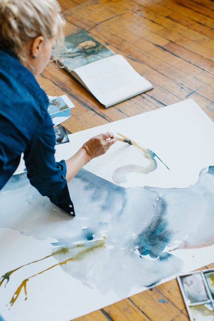 Holly Wach (artist) painting original bird watercolor art on the floor