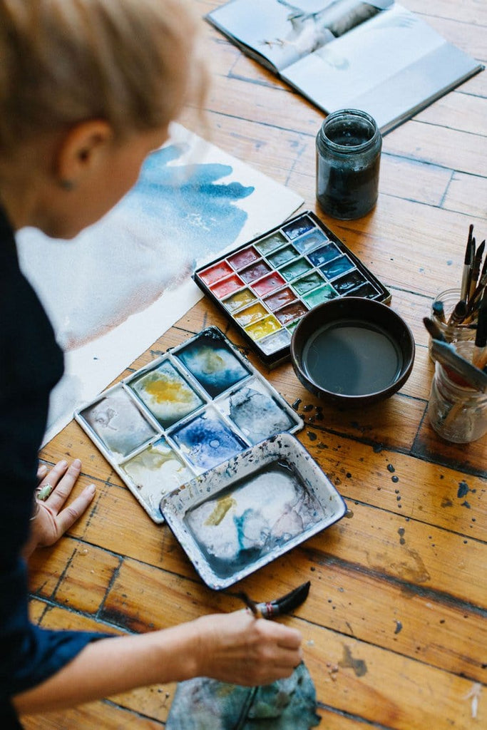 Holly Wach (artist) painting an original watercolor on the floor