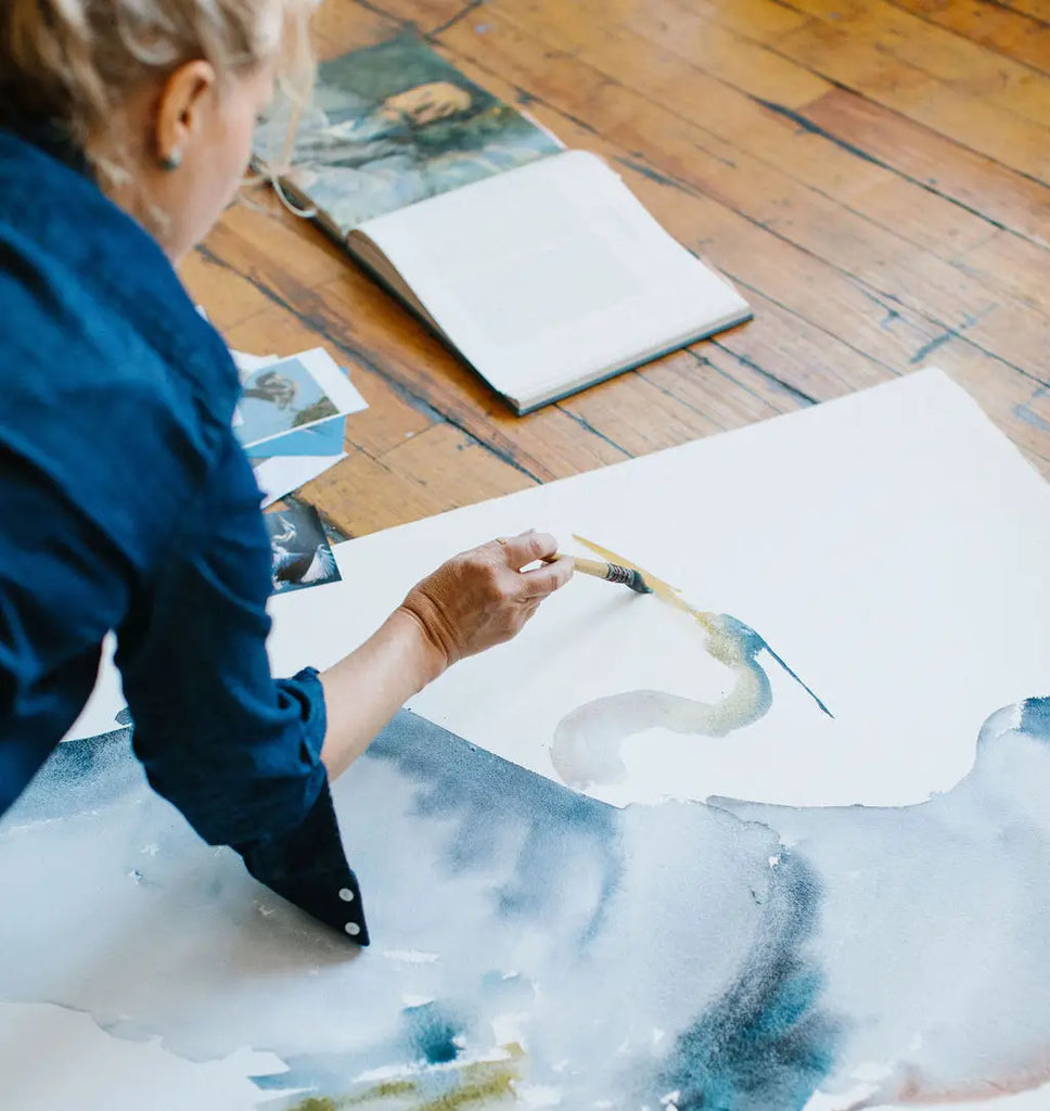 Holly Wach paints watercolors on the floor